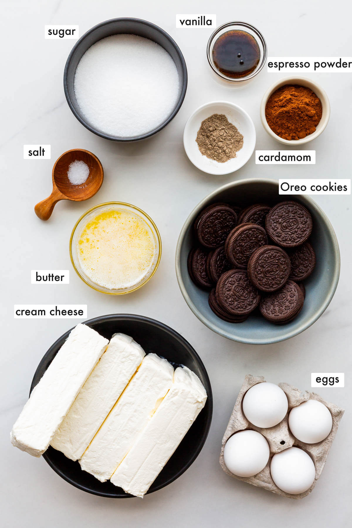 Ingredients to make a baked coffee-flavoured cheesecake with an Oreo cookie crust measured out and ready to be mixed.