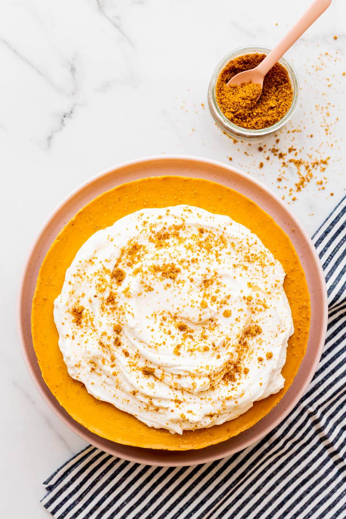 A baked pumpkin cheesecake topped with whipped cream.