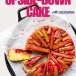 A rhubarb upside-down cake with raspberries creating a pink fruit layer over a moist vanilla cake.