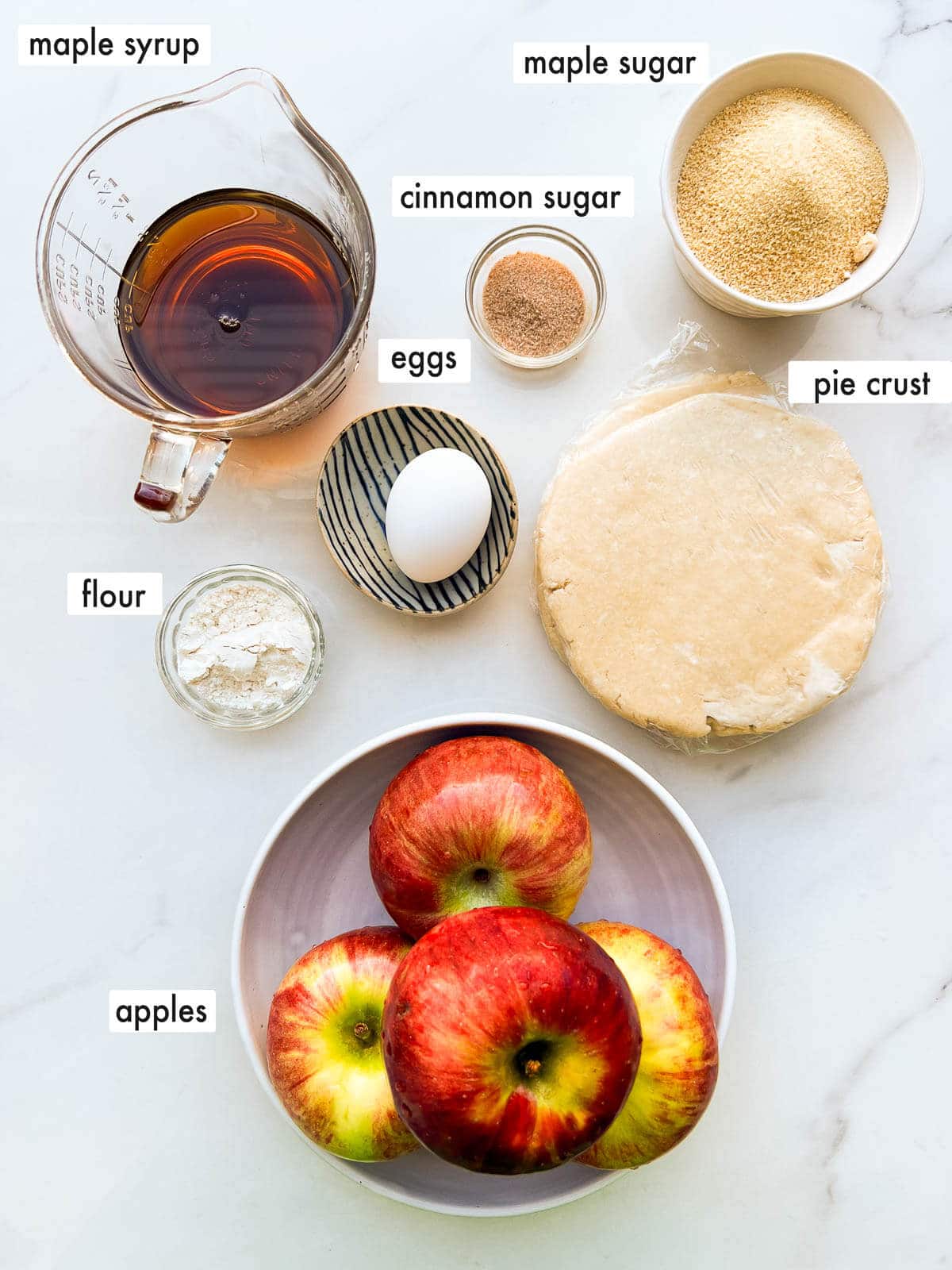 Ingredients to make a maple syrup apple pie from scratch.