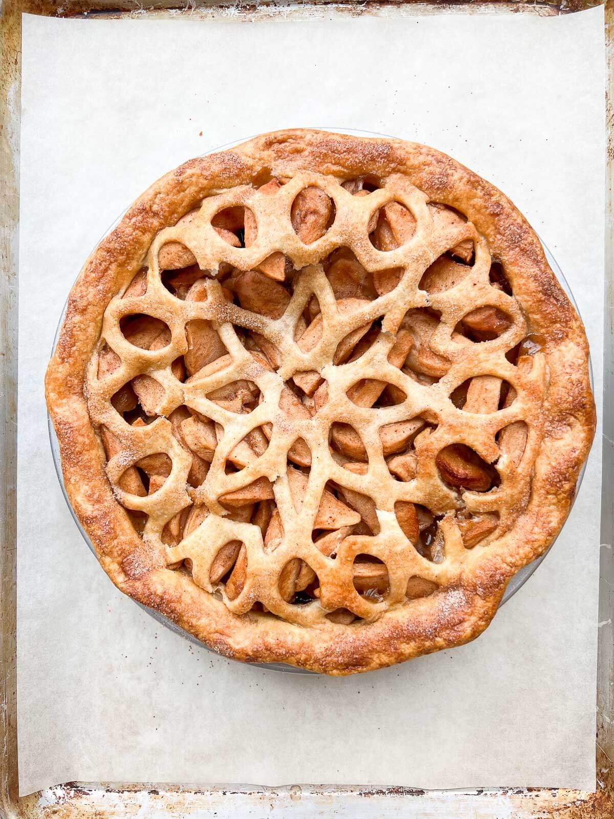 A freshly baked homemade apple pie cooling on a sheet pan.