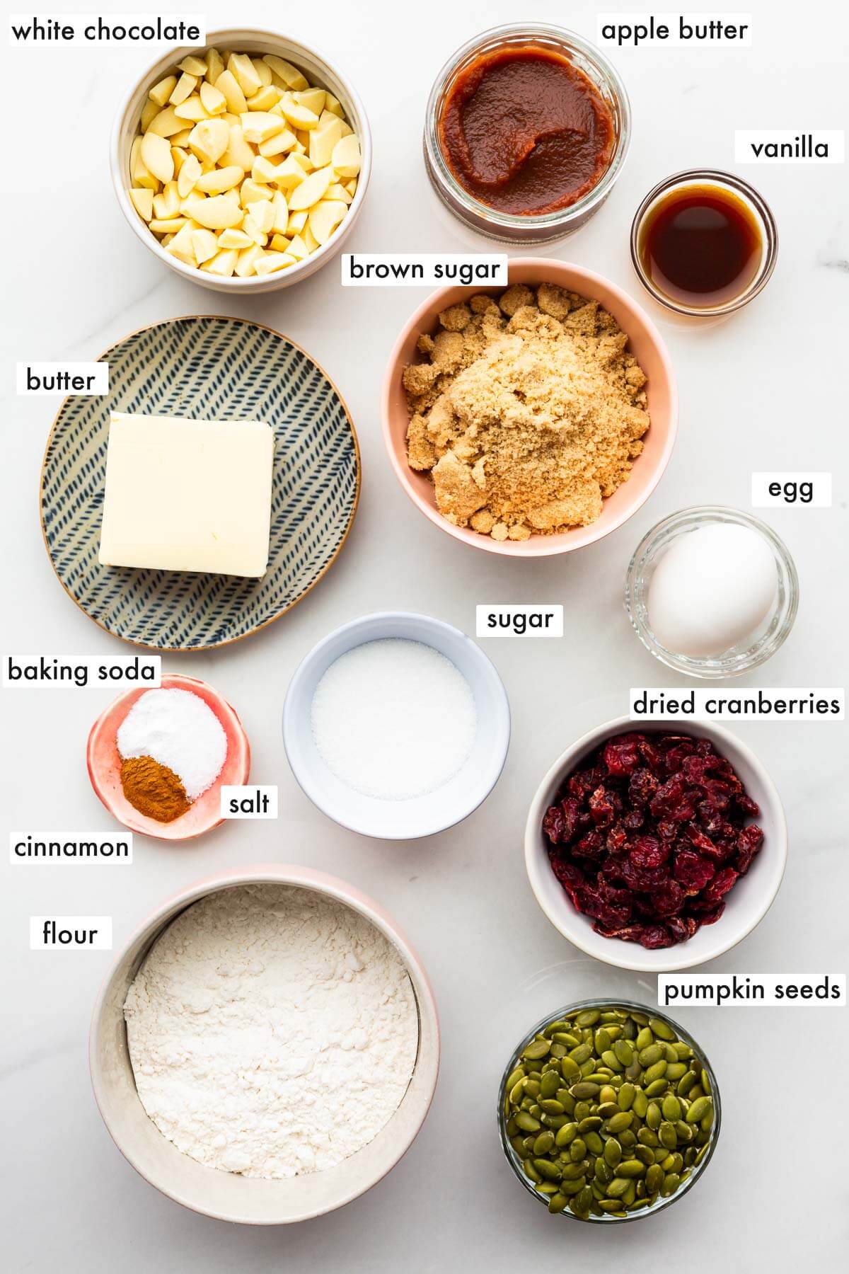 Ingredients to make fall cookies with apple butter, white chocolate, dried cranberries, and pumpkin seeds.