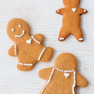 Gingerbread cookies shaped like people decorated with white royal icing.