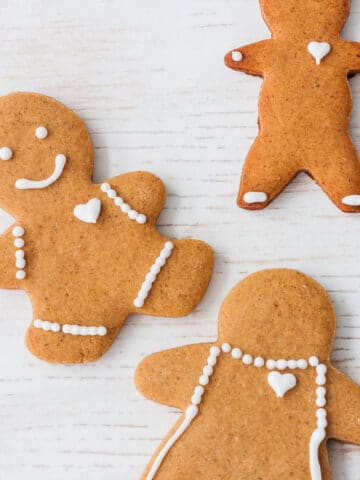 Gingerbread cookies shaped like people decorated with white royal icing.