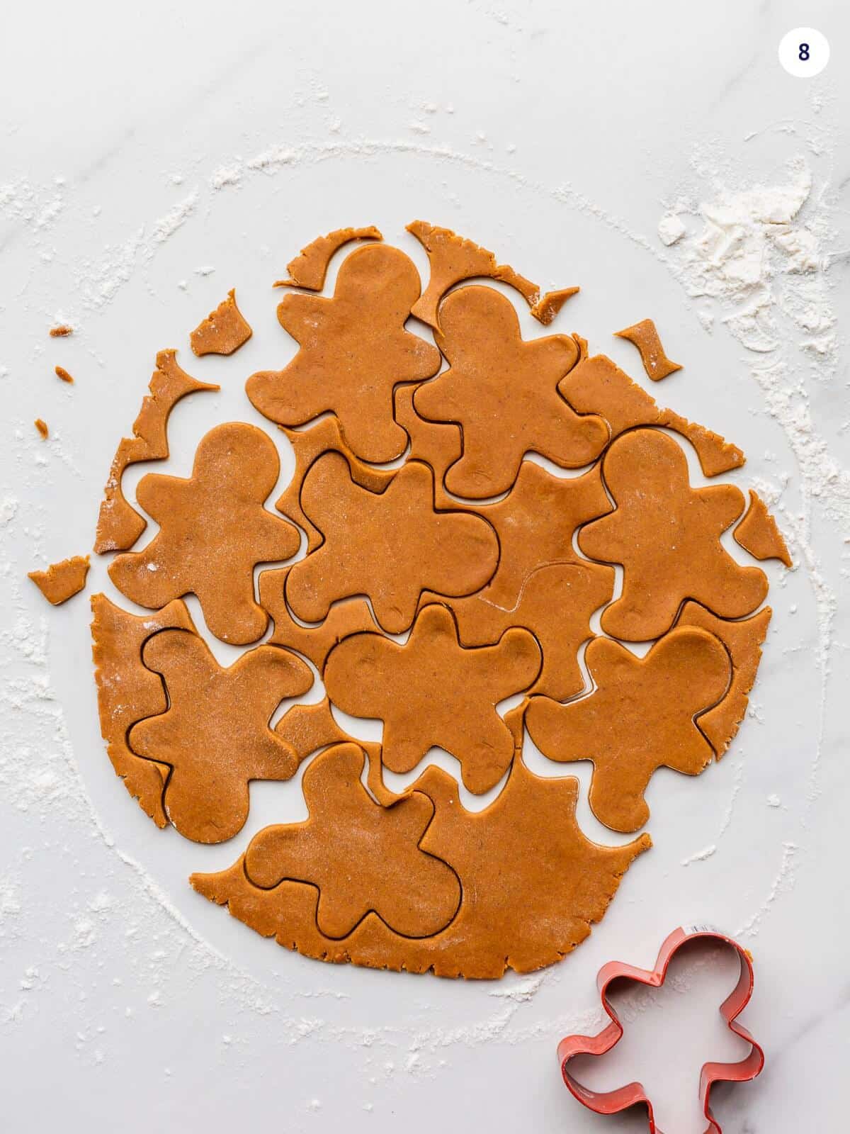 Rolled out gingerbread cookie dough being cut out with a cookie cutter.