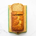 Banana bread on a cutting board being sliced.