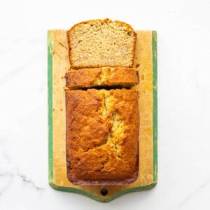 Banana bread on a cutting board being sliced.
