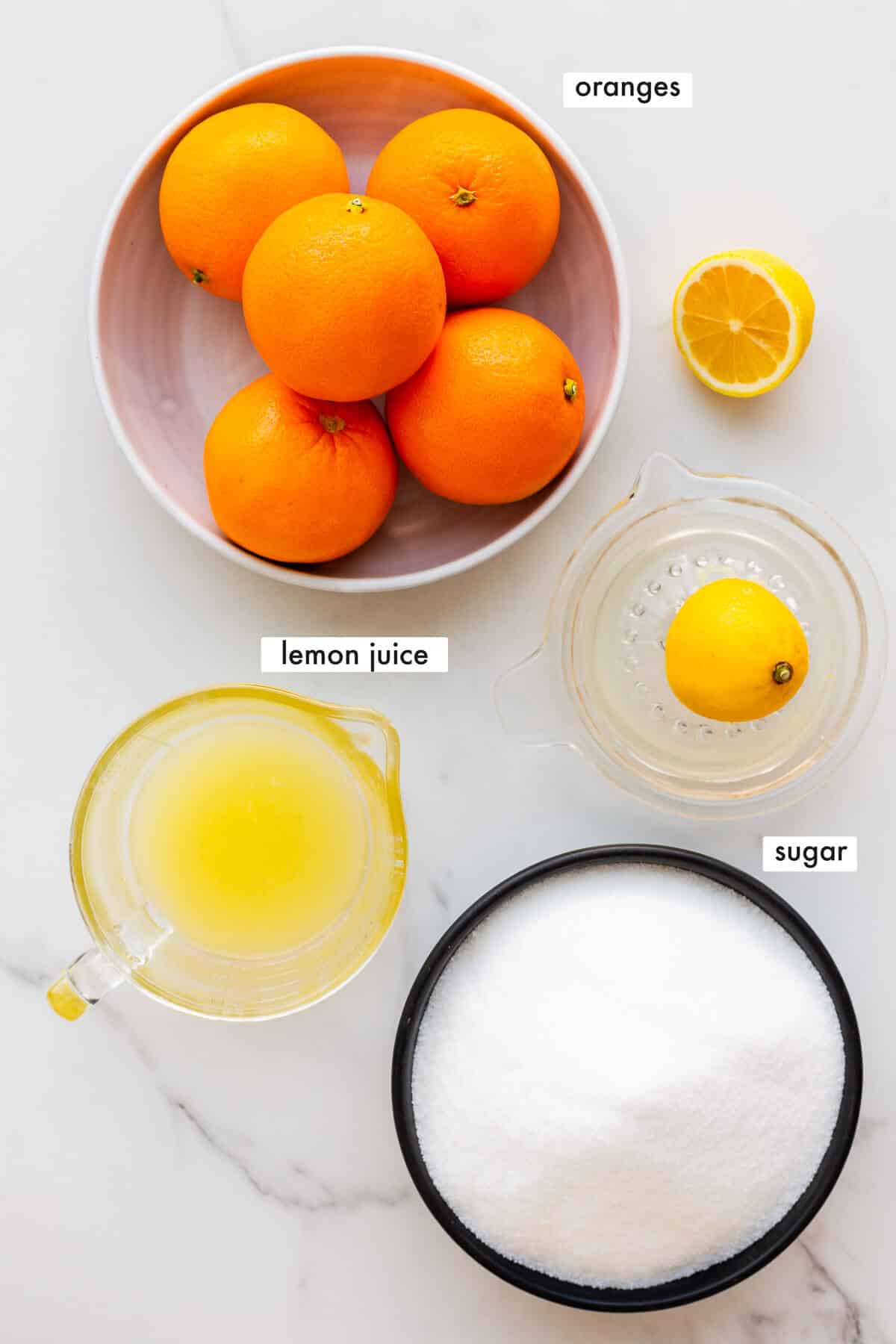 Ingredients to make orange marmalade from whole Navel oranges, sugar, and lemon juice, measured out.