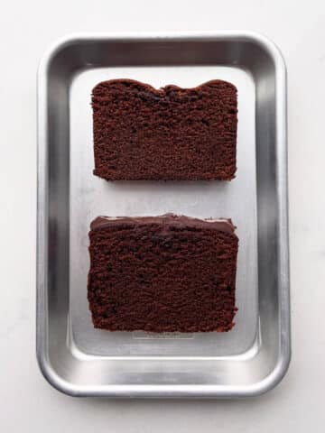 Two slices of chocolate loaf cake side-by-side to show one has collapsed in the middle.