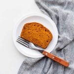 A slice of healthy pumpkin loaf on a dessert plate.