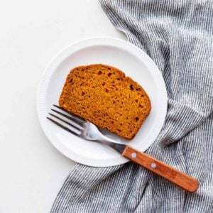 A slice of healthy pumpkin loaf on a dessert plate.