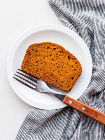 A slice of healthy pumpkin loaf on a dessert plate.