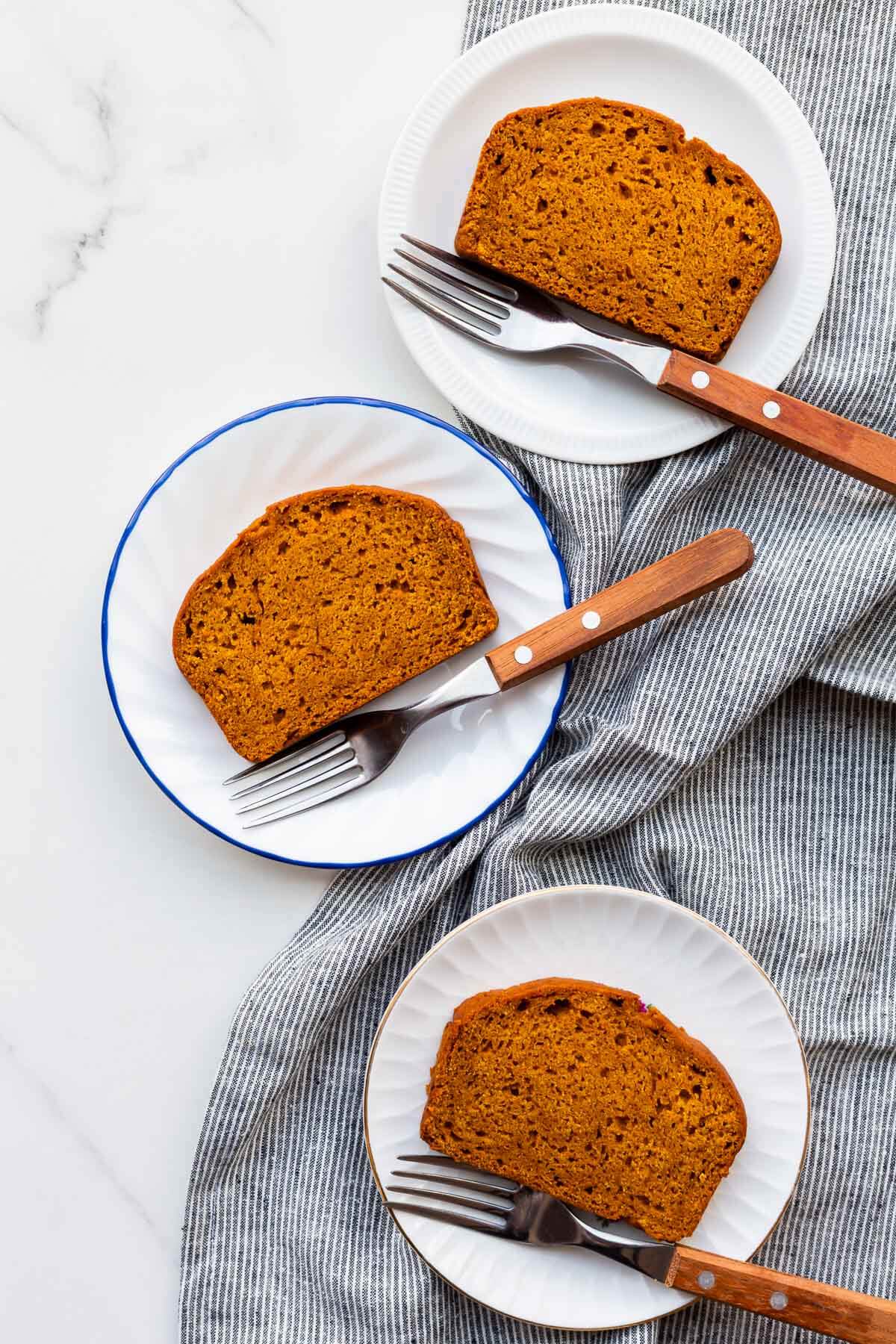 Slices of healthy pumpkin bread on dessert plates, ready to be eaten.