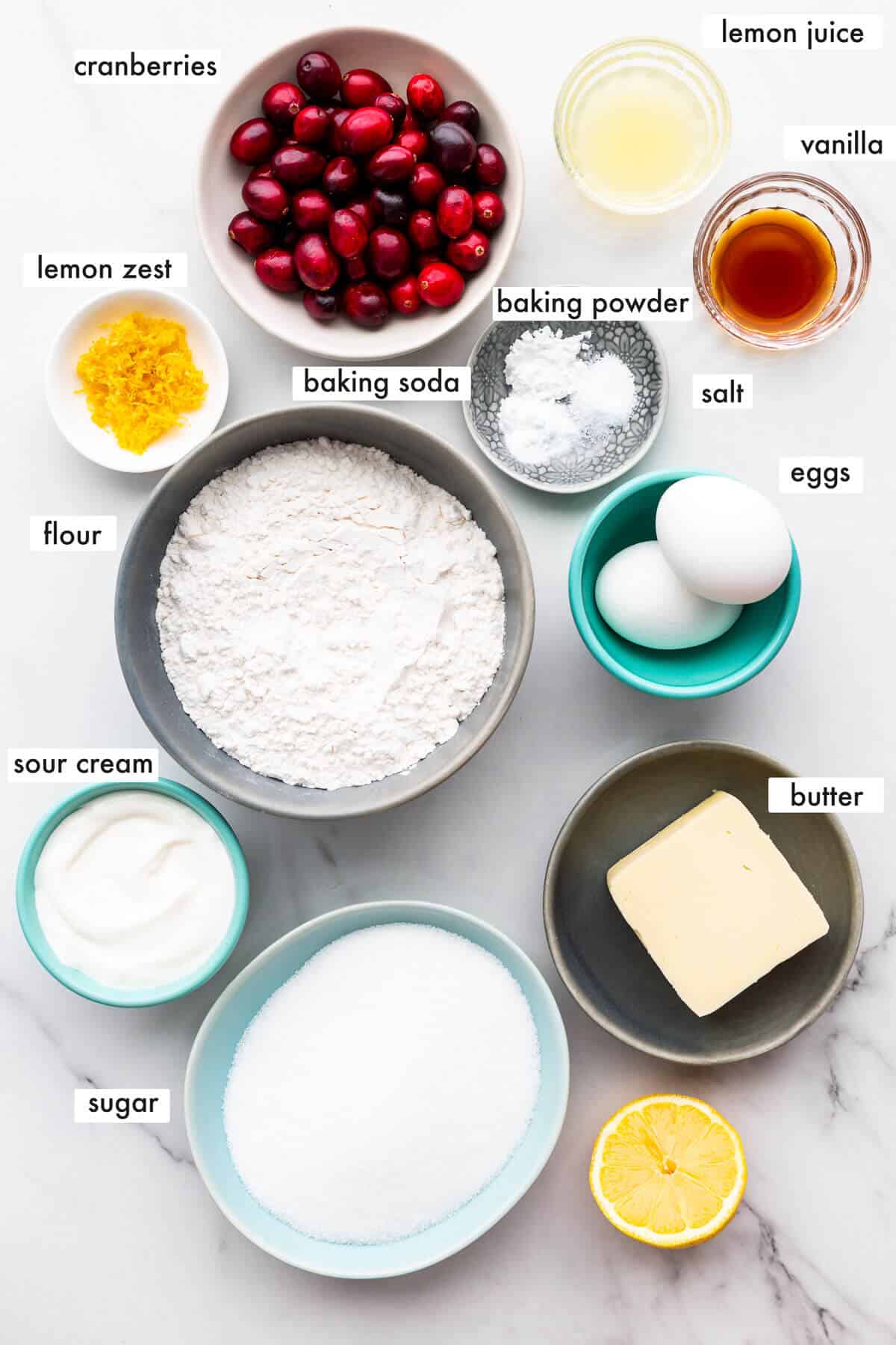 Ingredients to make cranberry lemon muffins with sour cream and fresh cranberries.